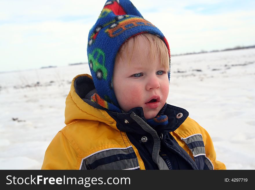 Infant boys first winter, out in snow bundled up in colorful snow gear. Infant boys first winter, out in snow bundled up in colorful snow gear.