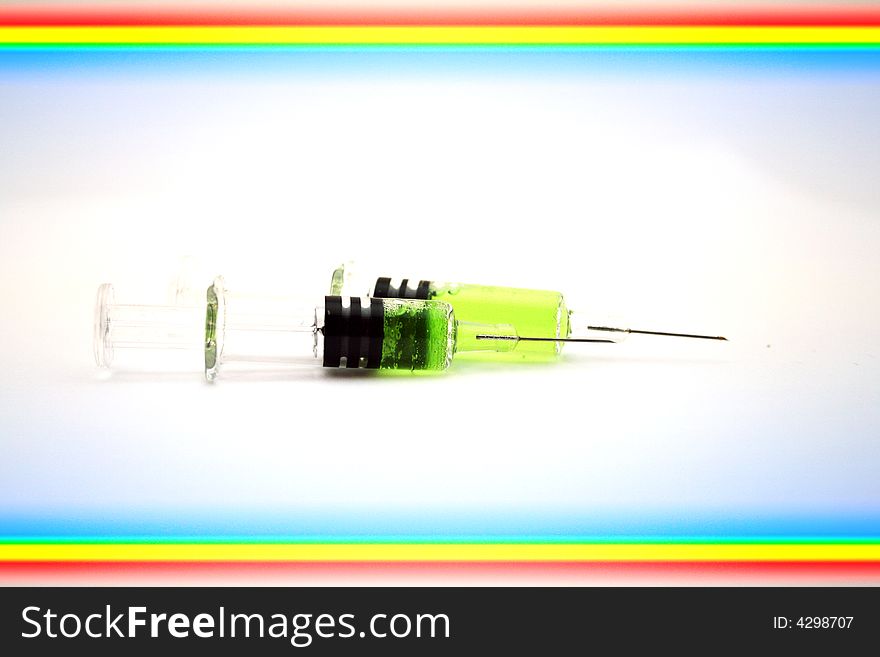 Syringe with green substance incide on white