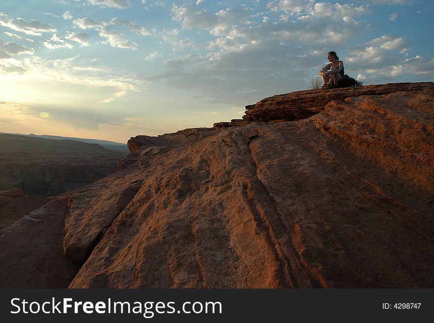 A sitting girl during a sunset at horseShoeBend