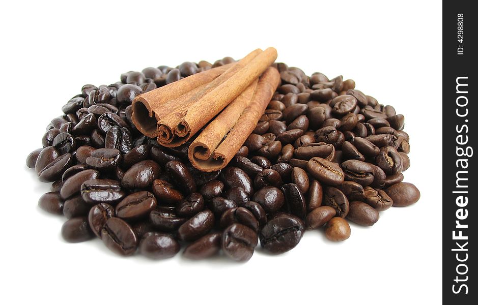 A pile of cinnamon sticks and two kinds coffee beans. A pile of cinnamon sticks and two kinds coffee beans