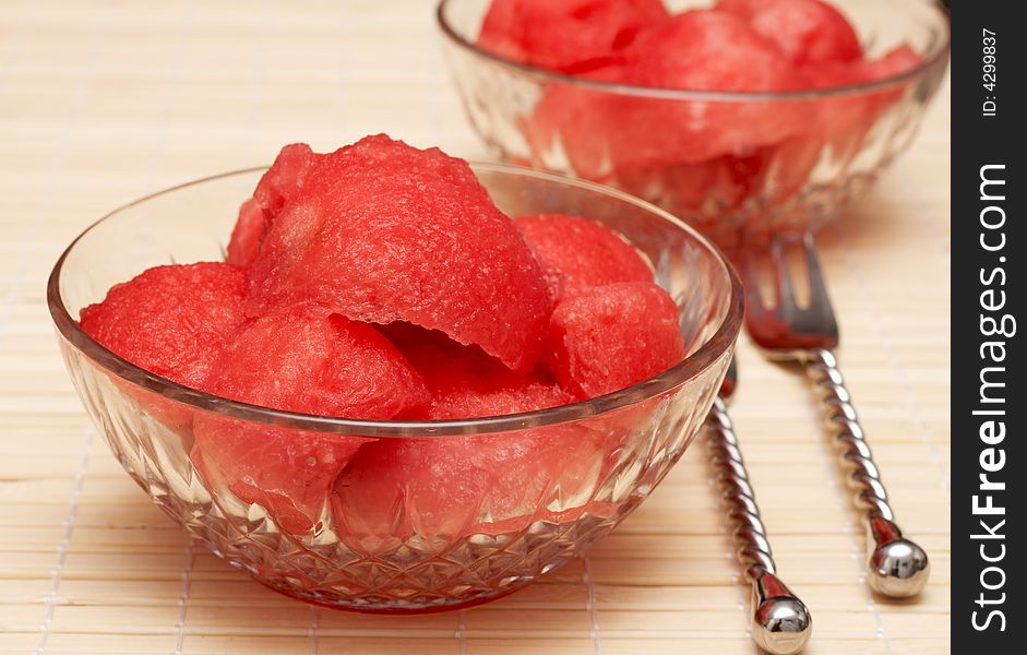 Juicy watermelon scoops in crystal bowls with silver decorative forks