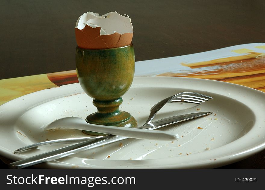 Picture of a finished breakfast, the crumbs and eggshell are still on the table.
