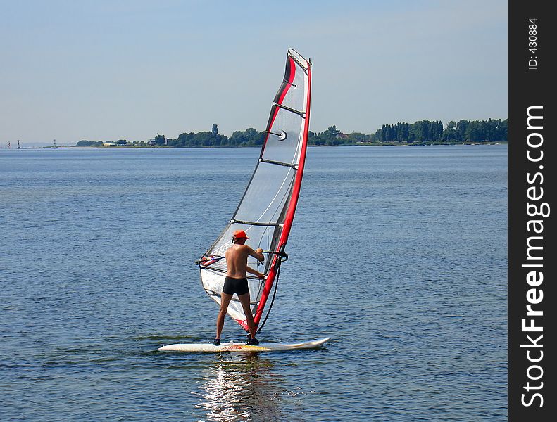 Photo of a windsurfer on the sea, taking his first lessons. Photo of a windsurfer on the sea, taking his first lessons