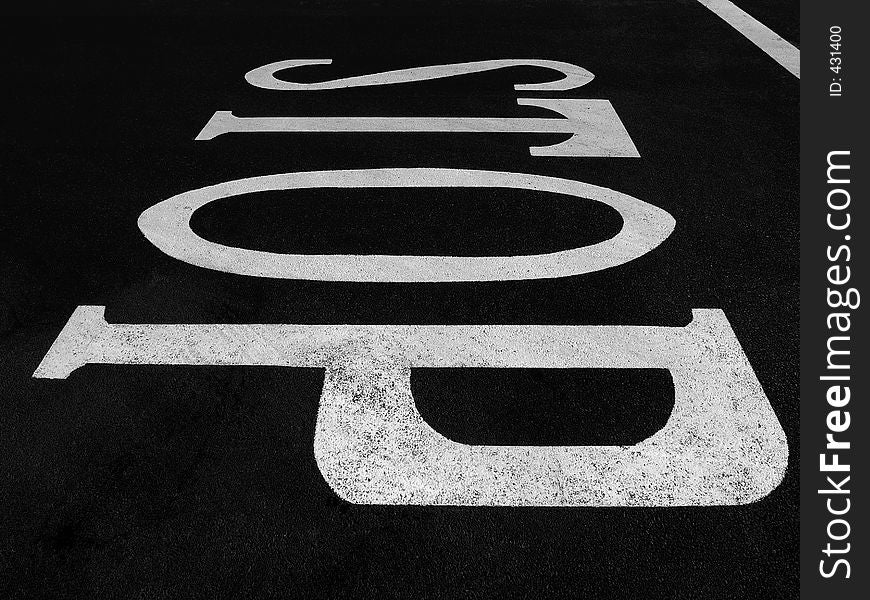 Wide angle view of the word 'STOP' painted on the road.