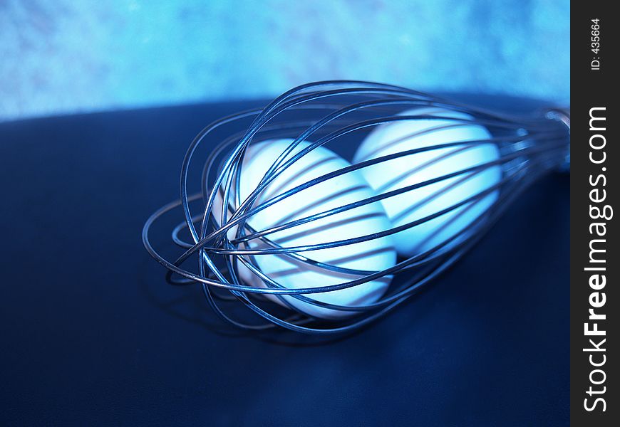 Two eggs in whisk (blue tint)