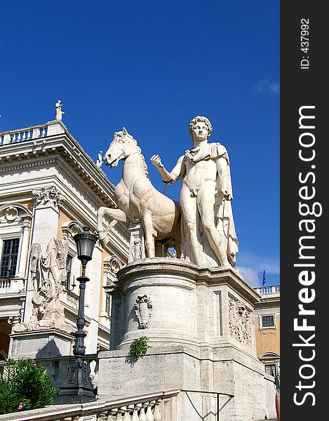 A statue of the mythological figure, Pollux, and his horse outside an ornate building. A statue of the mythological figure, Pollux, and his horse outside an ornate building.
