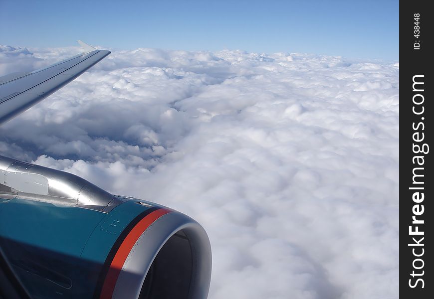 Airplane engine and wing gliding above thick white clouds. Airplane engine and wing gliding above thick white clouds