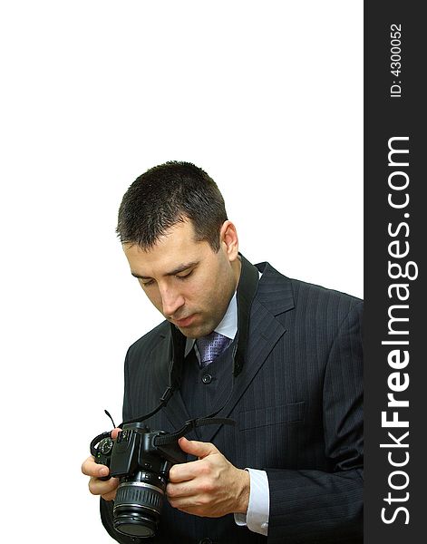 A man, wearing a suit, holding a camera, getting familiar with its functions. A man, wearing a suit, holding a camera, getting familiar with its functions