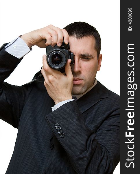 A man, wearing a suit, holding a camera vertically, taking a portrait shot. A man, wearing a suit, holding a camera vertically, taking a portrait shot