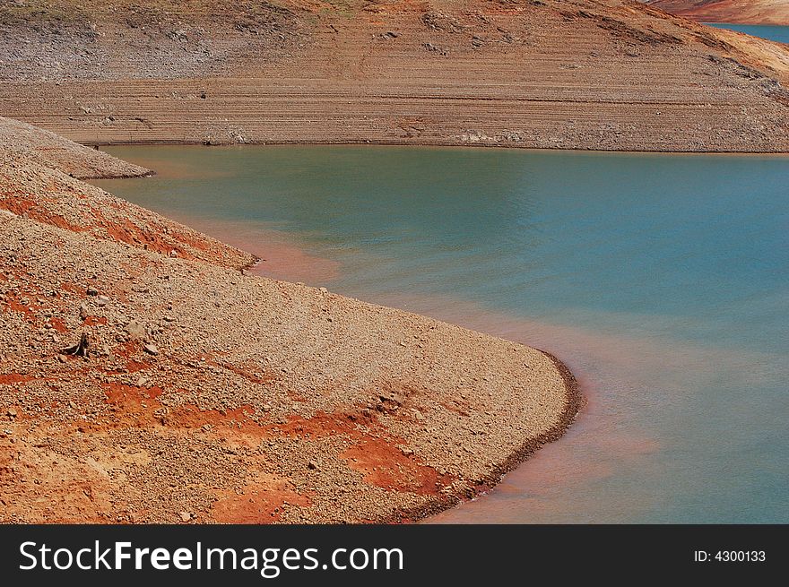 Shasta Lake is a reservoir created by the building of Shasta Dam in California, USA. Shasta Lake is the 3rd largest lake in California. This photo shows the extreme iron content of the deposits around the lake. Shasta Lake is a reservoir created by the building of Shasta Dam in California, USA. Shasta Lake is the 3rd largest lake in California. This photo shows the extreme iron content of the deposits around the lake