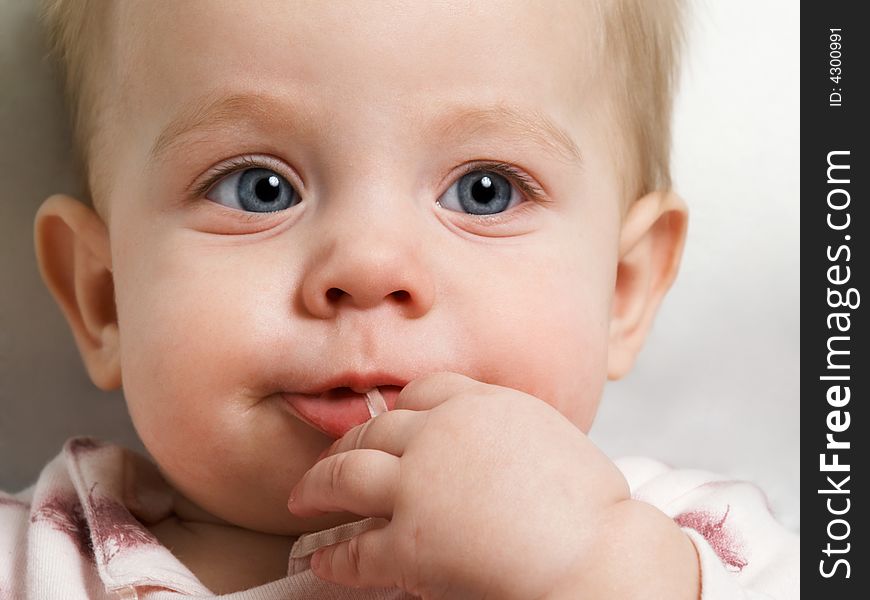 Baby with blue eyes on grey background. Baby with blue eyes on grey background