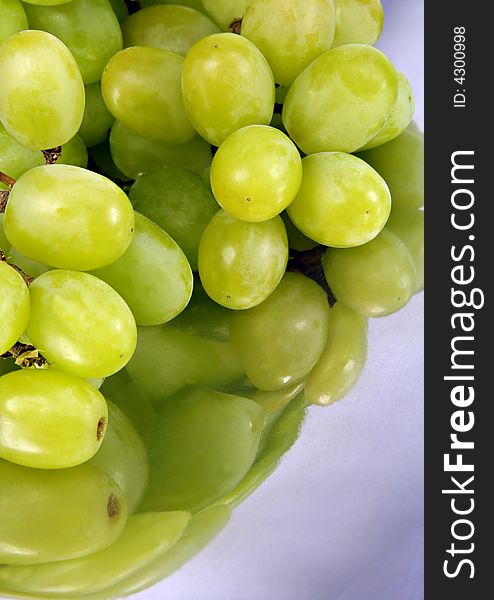Green Grapes in a stainless steel dish with reflections.