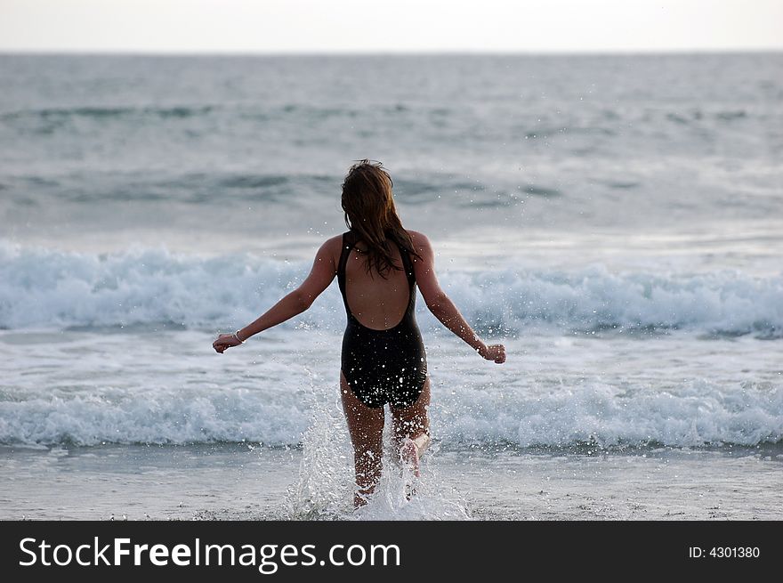 Teen model running into the waves. Teen model running into the waves.