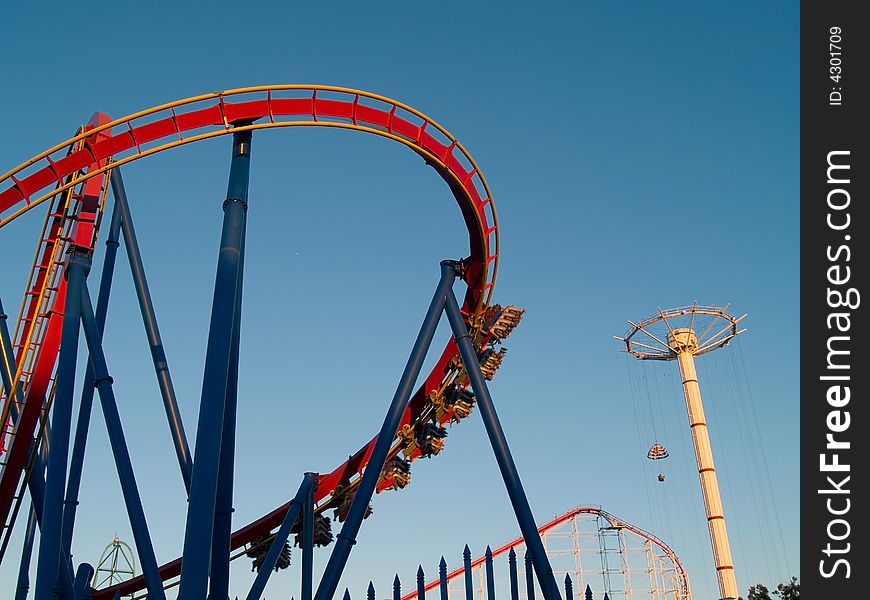 A modern roller coaster in a theme park. A modern roller coaster in a theme park.