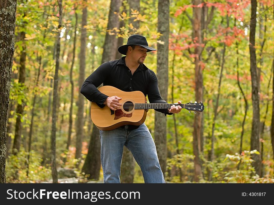 A shot of a young manpicking a guitar. A shot of a young manpicking a guitar.
