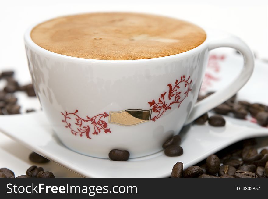 Cup of coffee and grains over white