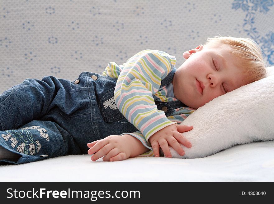 The small beautiful boy sleeps a head on a pillow. The small beautiful boy sleeps a head on a pillow