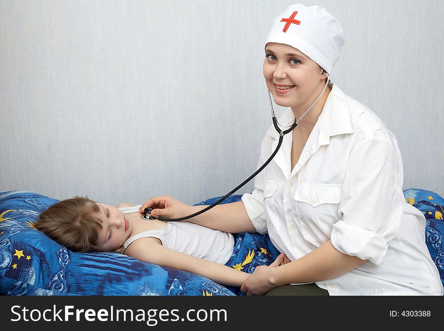 A doctor examines a girl with phonendoscope. A doctor examines a girl with phonendoscope