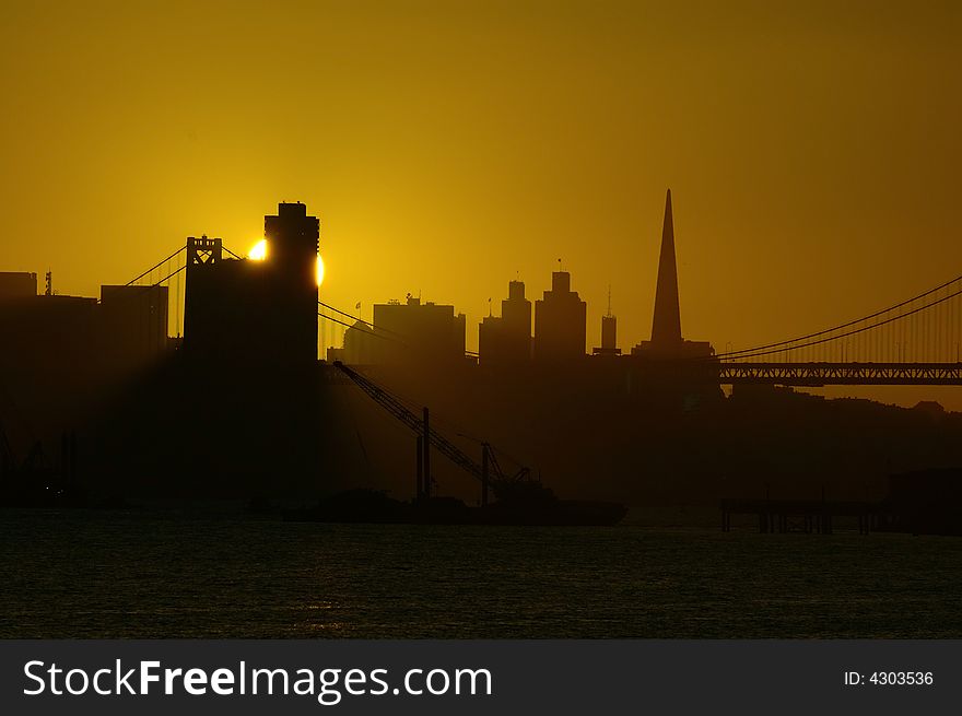 Sun sets in downtown San Francisco.  This photograph was taken from Oakland harbor. Sun sets in downtown San Francisco.  This photograph was taken from Oakland harbor.