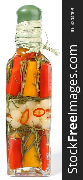 Marinated vegetables in glass bottle on white