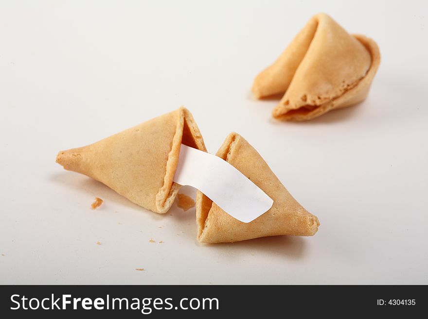 A couple of fortune cookies with a blanc white note