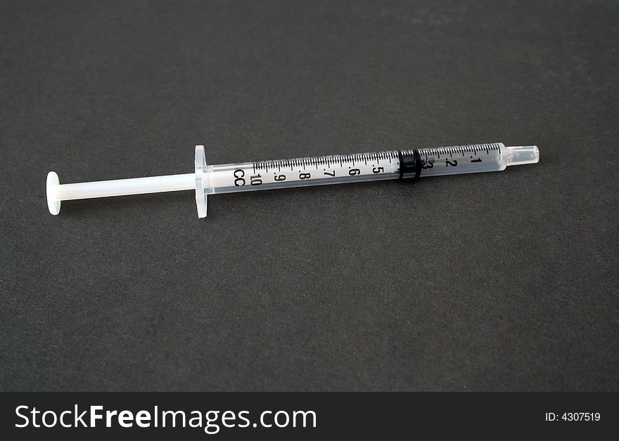 Hypodermic needle on a grey background