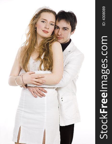 The pair embraces in white clothes. The pair embraces in white clothes
