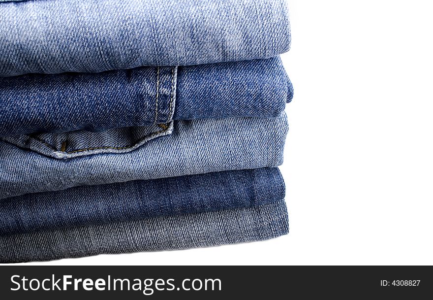 Stack of blue jeans over white