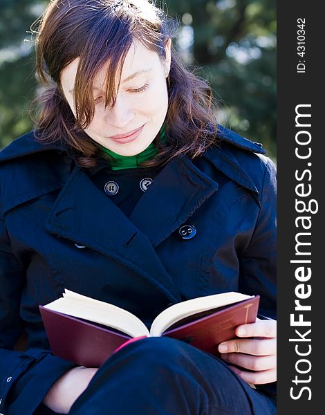 Young woman enjoying a book in the park. Young woman enjoying a book in the park