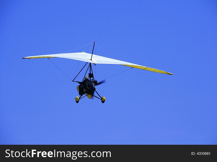 Ultralight aircraft in flight against the blue sky. Ultralight aircraft in flight against the blue sky