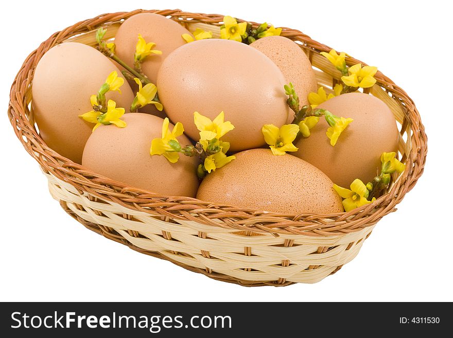 A basket of eggs with flowers isolated on the white background. A basket of eggs with flowers isolated on the white background