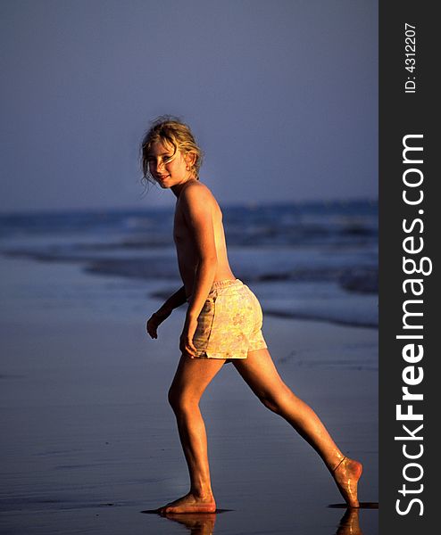 Young Girl Strolling Along The Beach