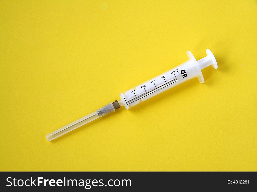 Syringe isolated on yellow background. Syringe isolated on yellow background.