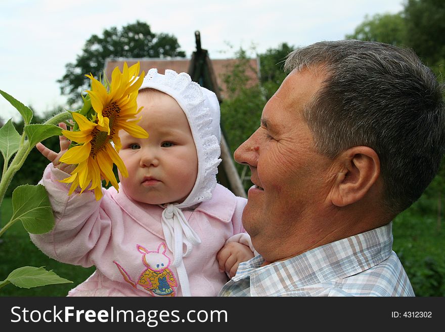 Grandfather and granddaughter enjoying the sunflower