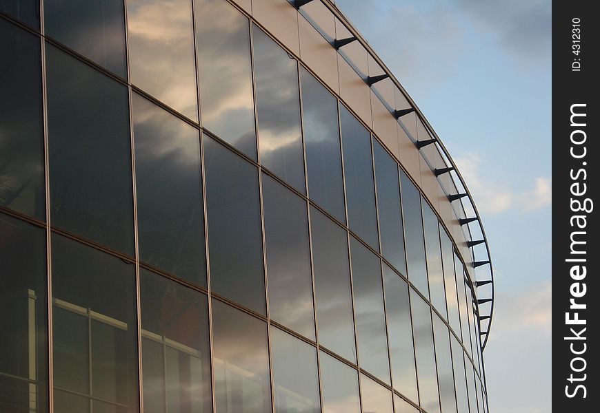 Clouds reflection on the sport arena glass and steel facing. Clouds reflection on the sport arena glass and steel facing.