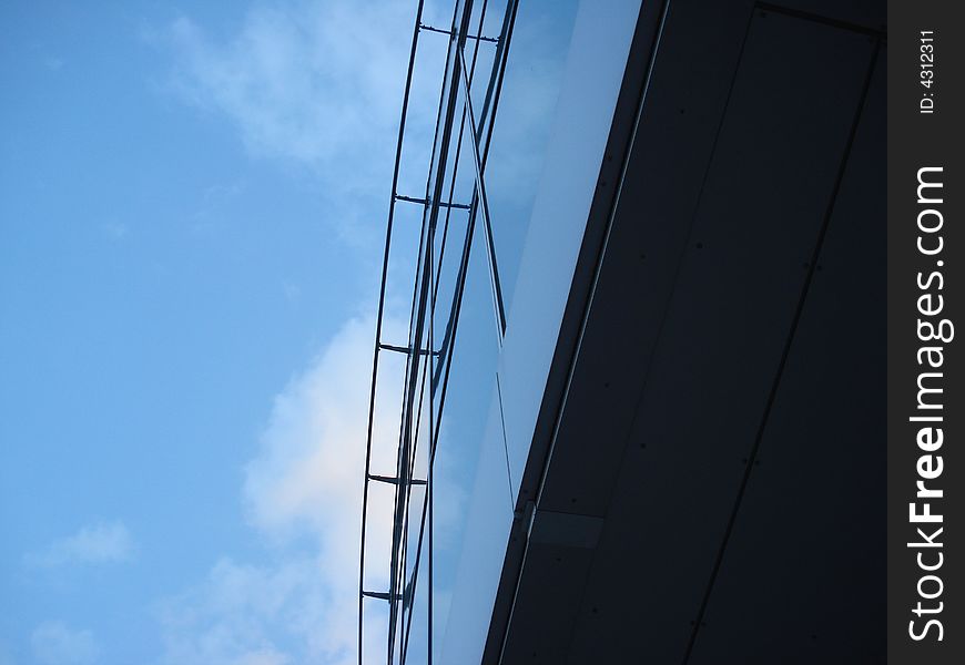 Sky reflection on the sport arena glass and steel facing. Sky reflection on the sport arena glass and steel facing.