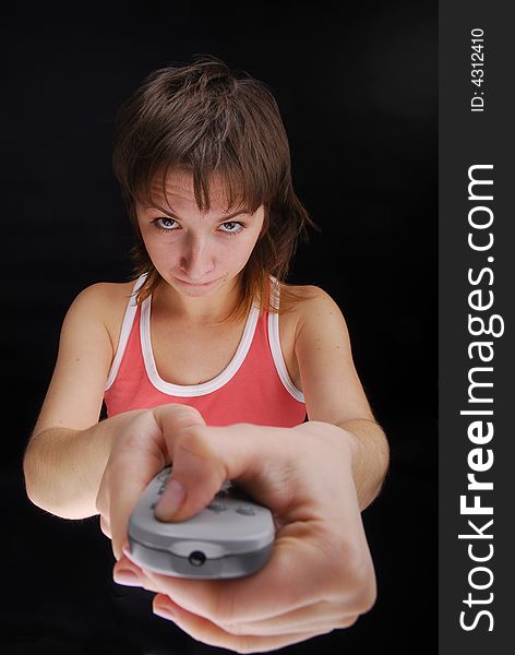 Young woman with tv remote control , isolated on black background. Young woman with tv remote control , isolated on black background