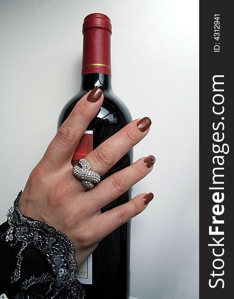 Female hand with bottle of red wine. Female hand with bottle of red wine