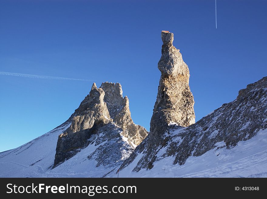 Snowy mountain cliff in blue sky, horizontal. Alps, EU.