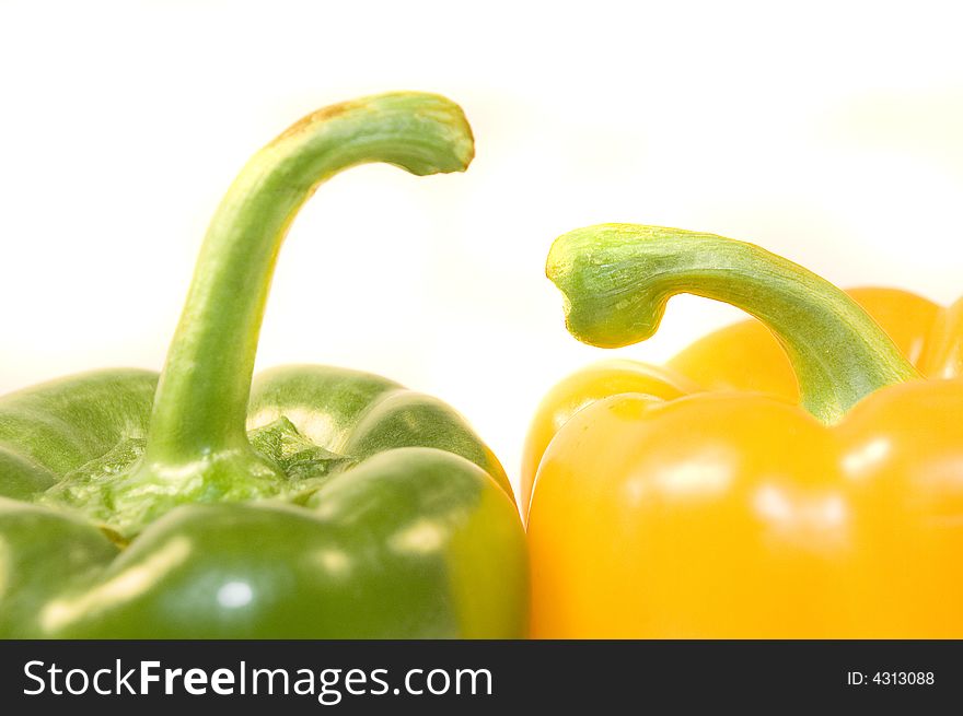 Green and yellow paprika on white background