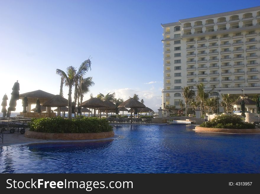 A large blue lagoon type pool at an oceanside resort hotel. A large blue lagoon type pool at an oceanside resort hotel