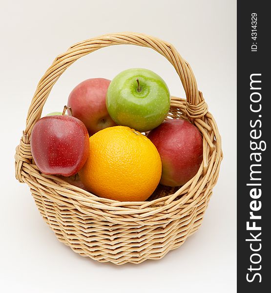 Fresh fruits in the basket on a grey background