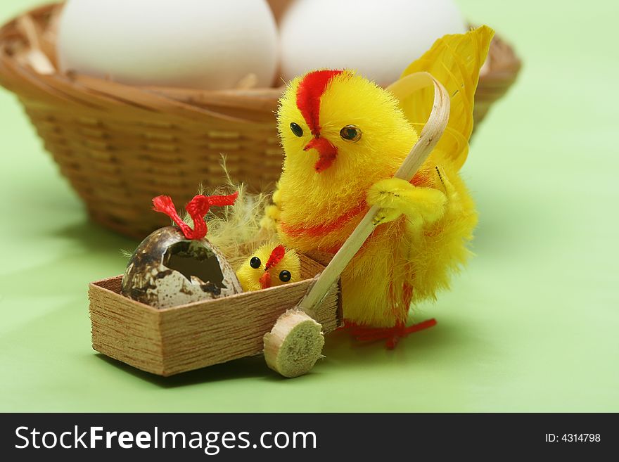 Easter motive.Hen and her chick,white eggs on green background.