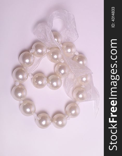 Pearls on a white tape in pink color