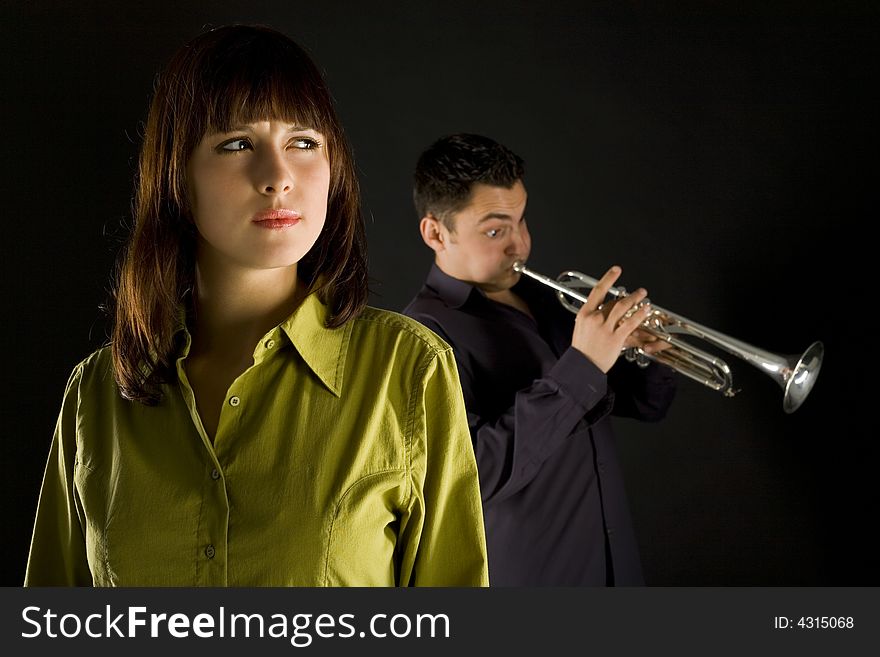 Trumpet man standing behind the woman. The woman looks thoughtful. Front view. Trumpet man standing behind the woman. The woman looks thoughtful. Front view.