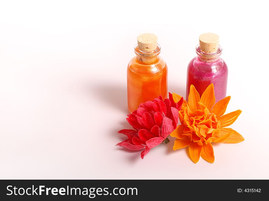 Two bottles, two flowers orange and pink color. Two bottles, two flowers orange and pink color