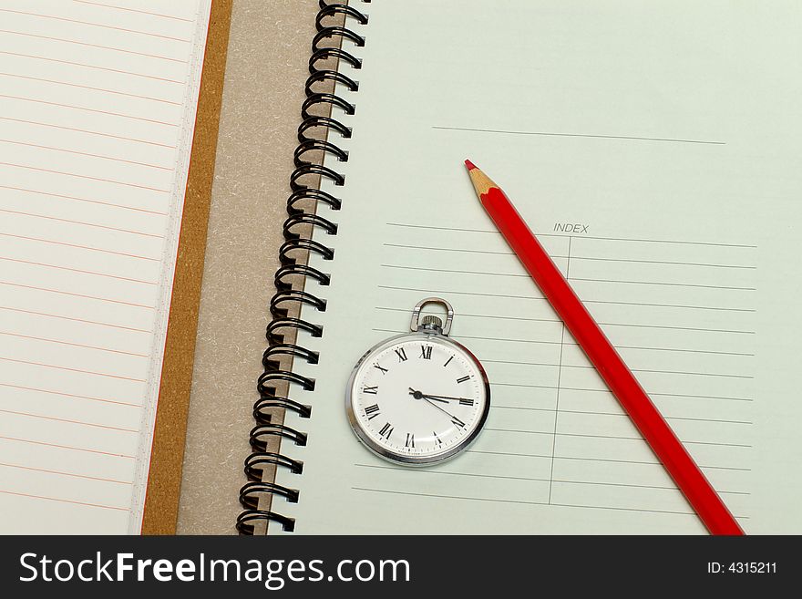 The note book with hours and a red pencil. The note book with hours and a red pencil