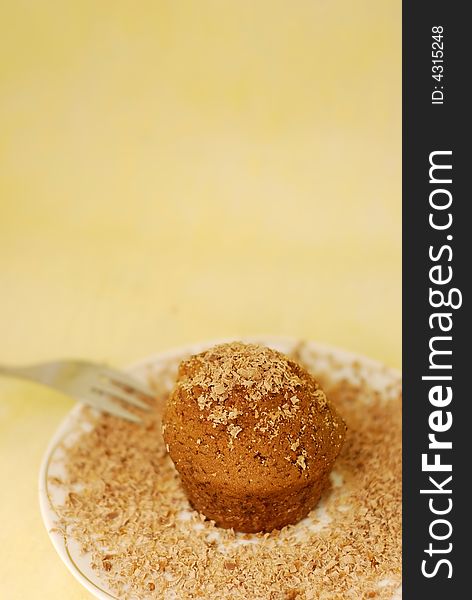 Chocolate muffin with small chocolate pieces on the plate with fork