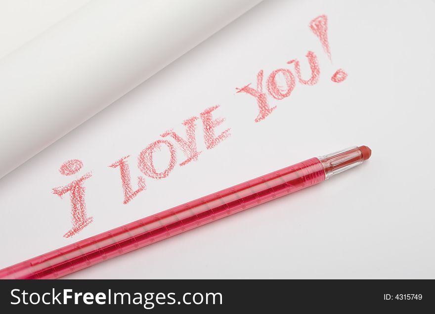 The red pencil lies on a white paper sheet, on sheet is written love message
