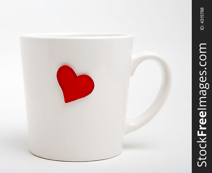 White cup with heart on a white background. White cup with heart on a white background